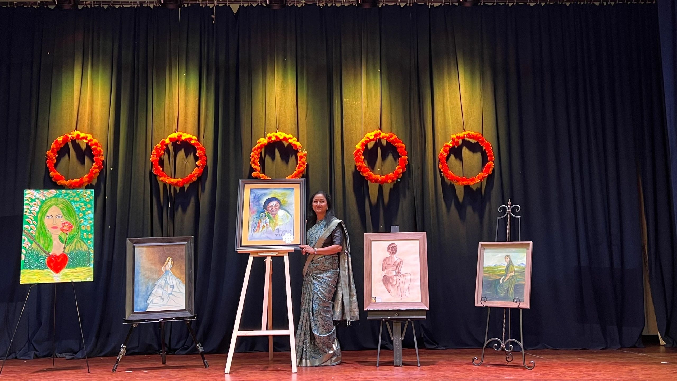Santvana Jain with her paintings on display at an exhibition
